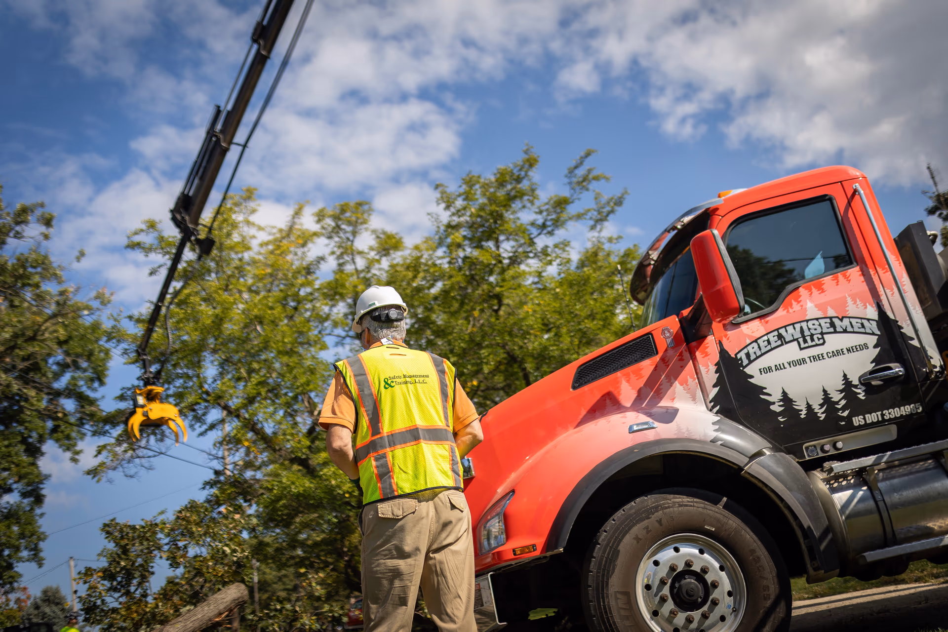 ISA Certified Arborist directing a crane-assisted tree removal