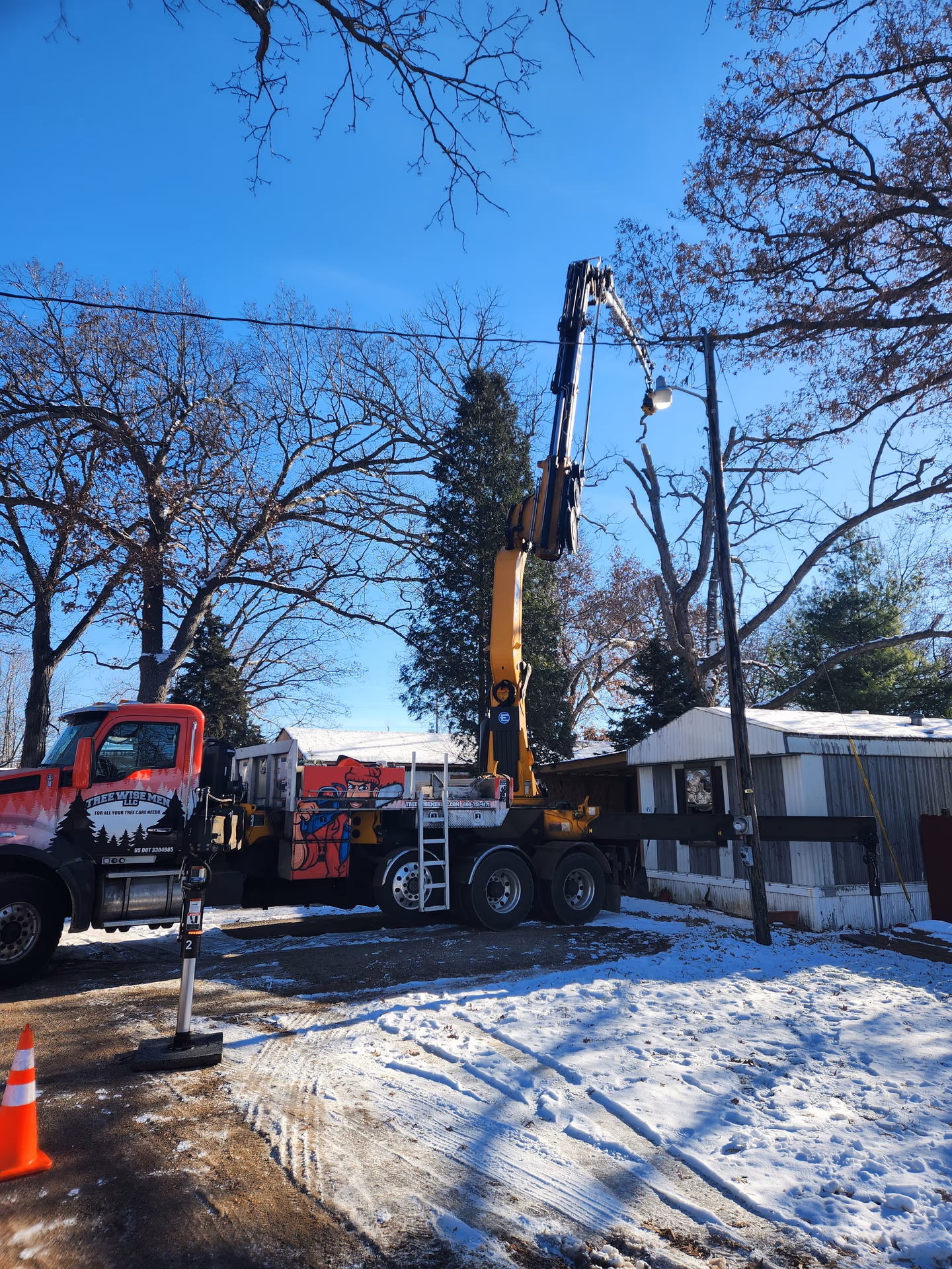 Crane-assisted removal of a dead oak leaning over a home in Southern Wisconsin
