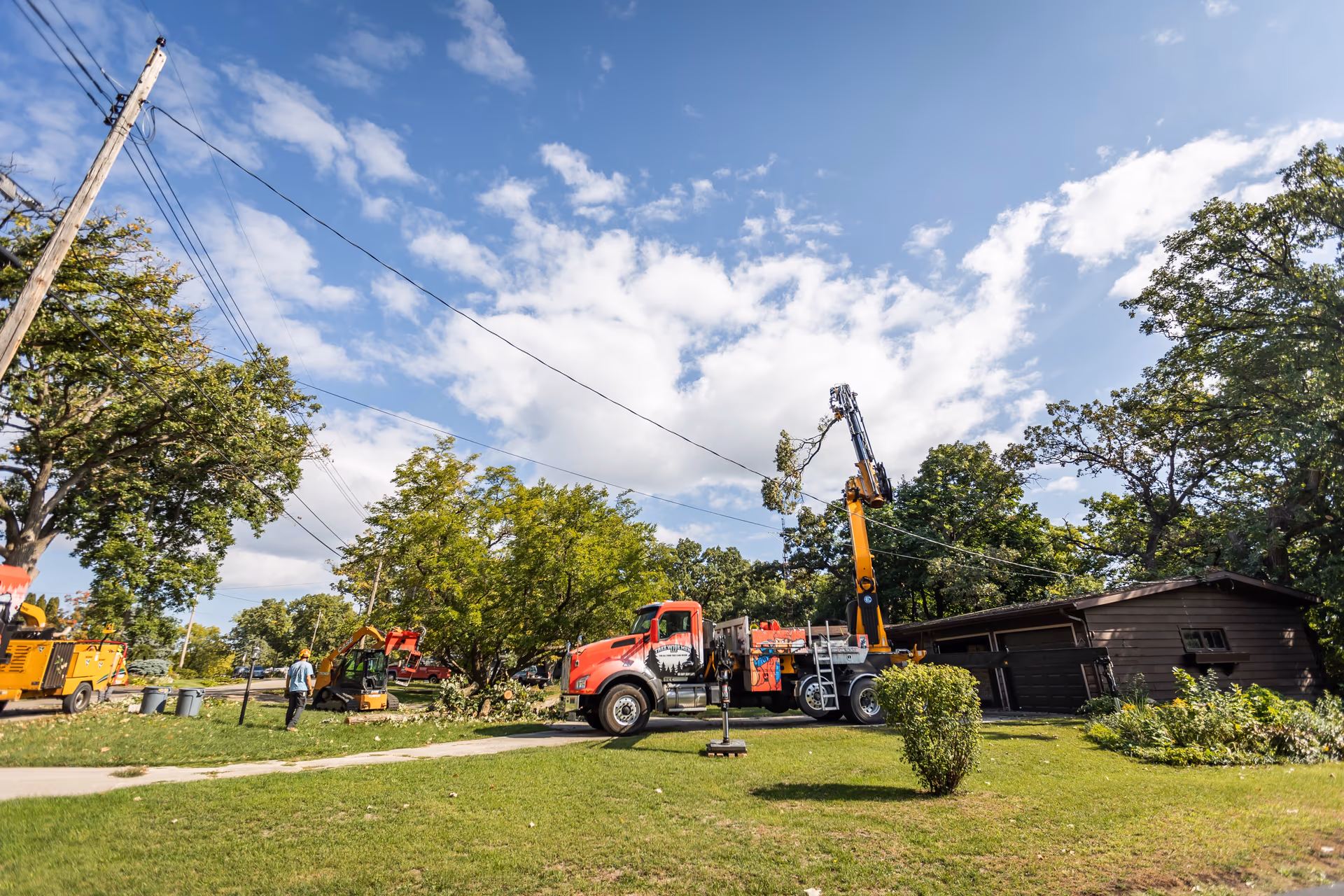 Crane boom extended over neighborhood canopy during storm response