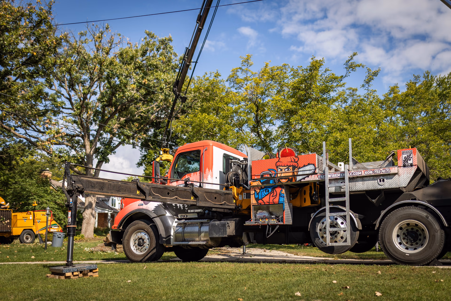Crane truck loading cut logs on a residential removal