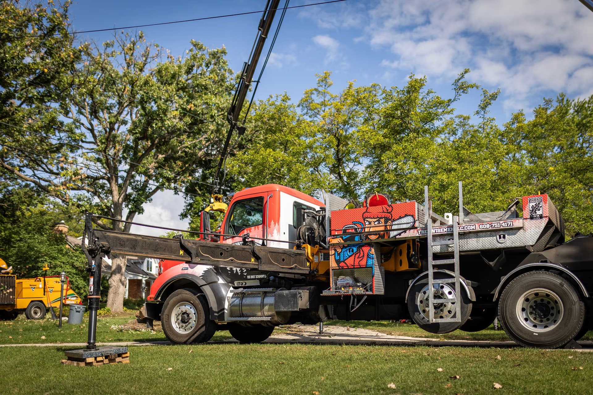 Crane truck loading cut logs on a residential removal