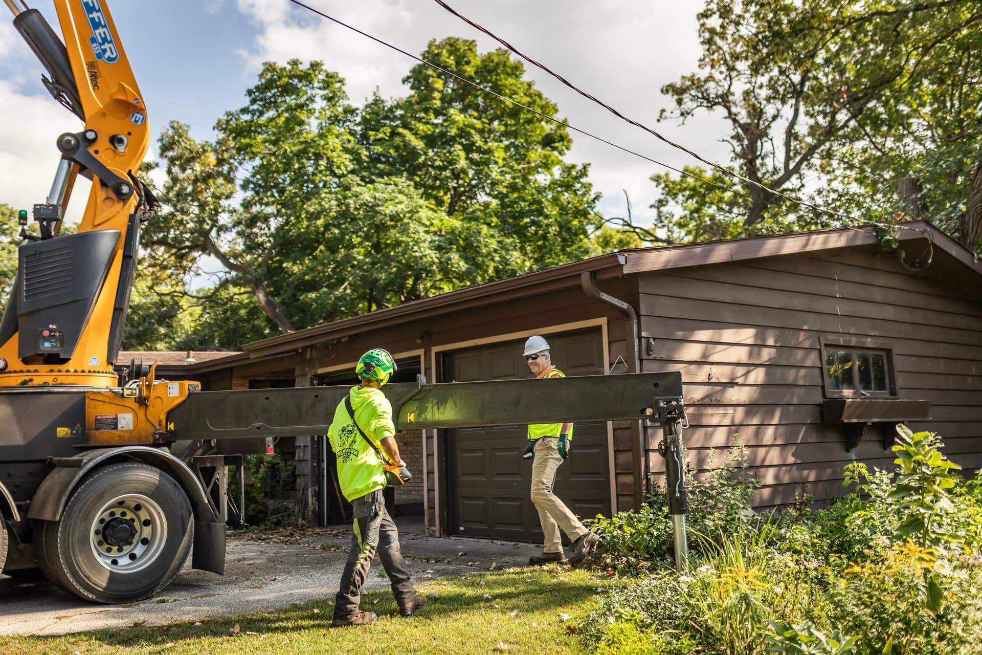 Tree Wise Men crew and crane working beside a house during an emergency removal