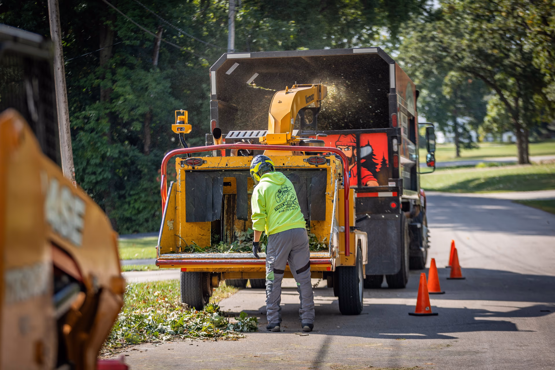 Crew loading a chipper roadside at a multi-family property