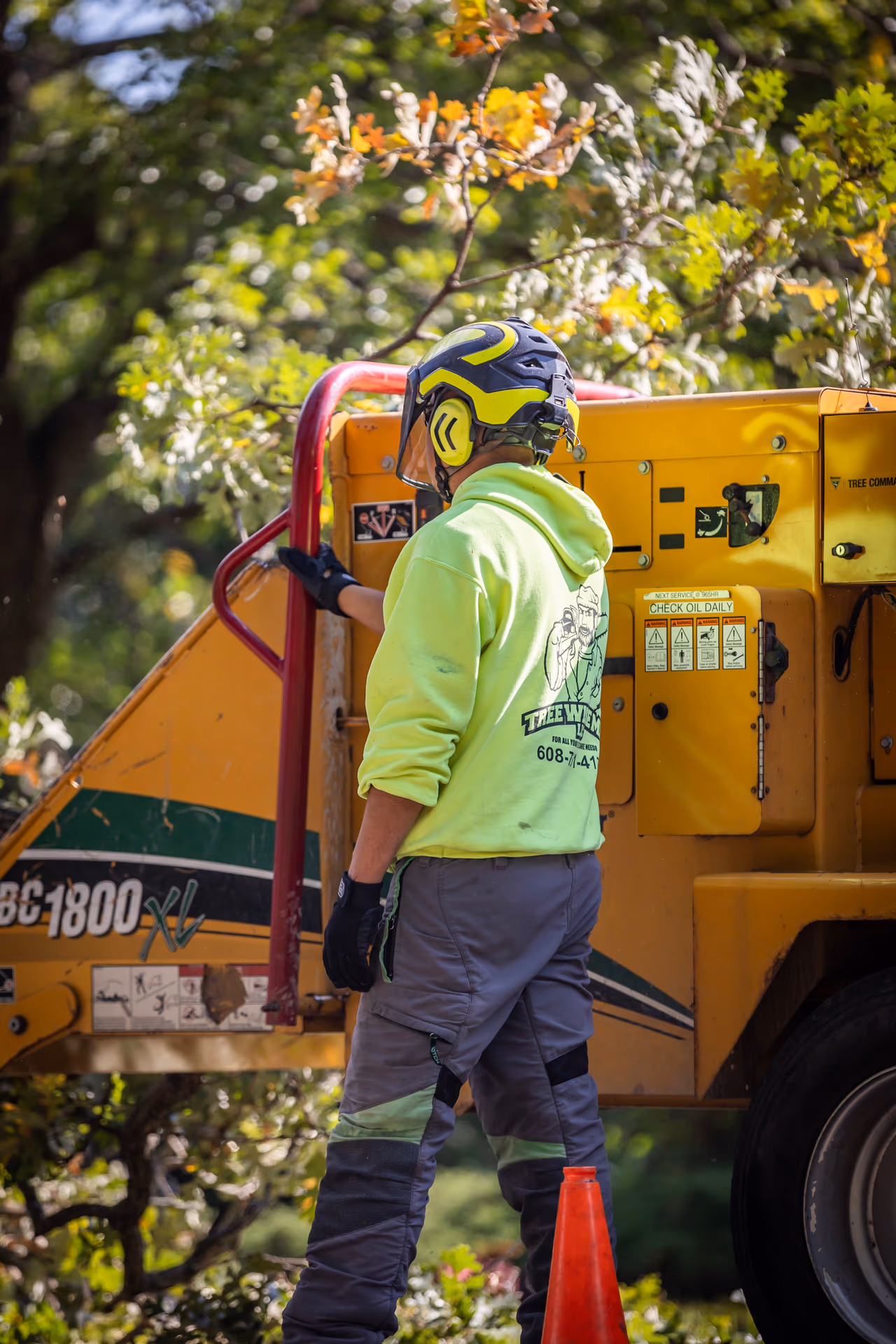 Crew member feeding brush into the chipper on a campus-area job