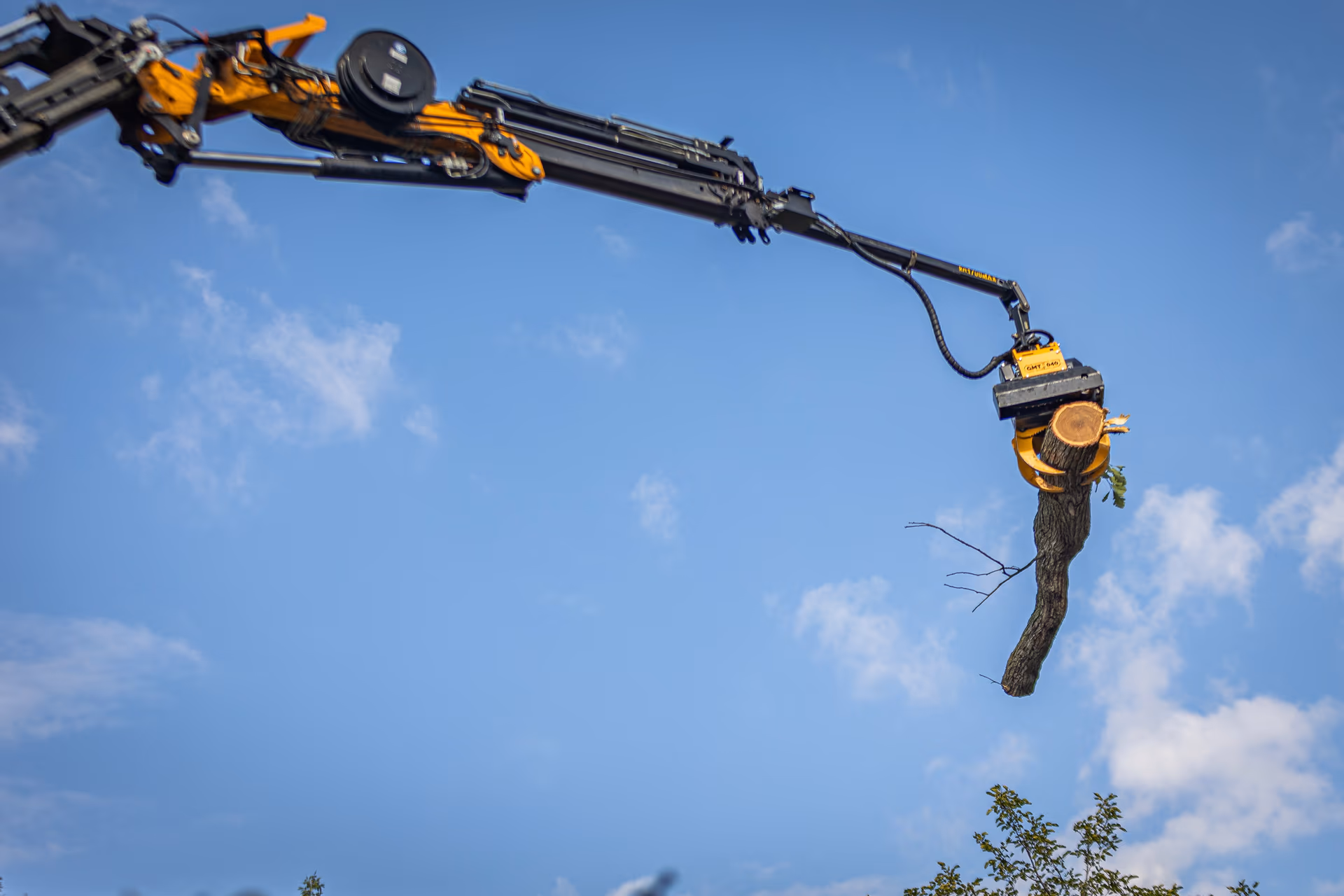 Grapple saw boom extended against a clear Wisconsin sky