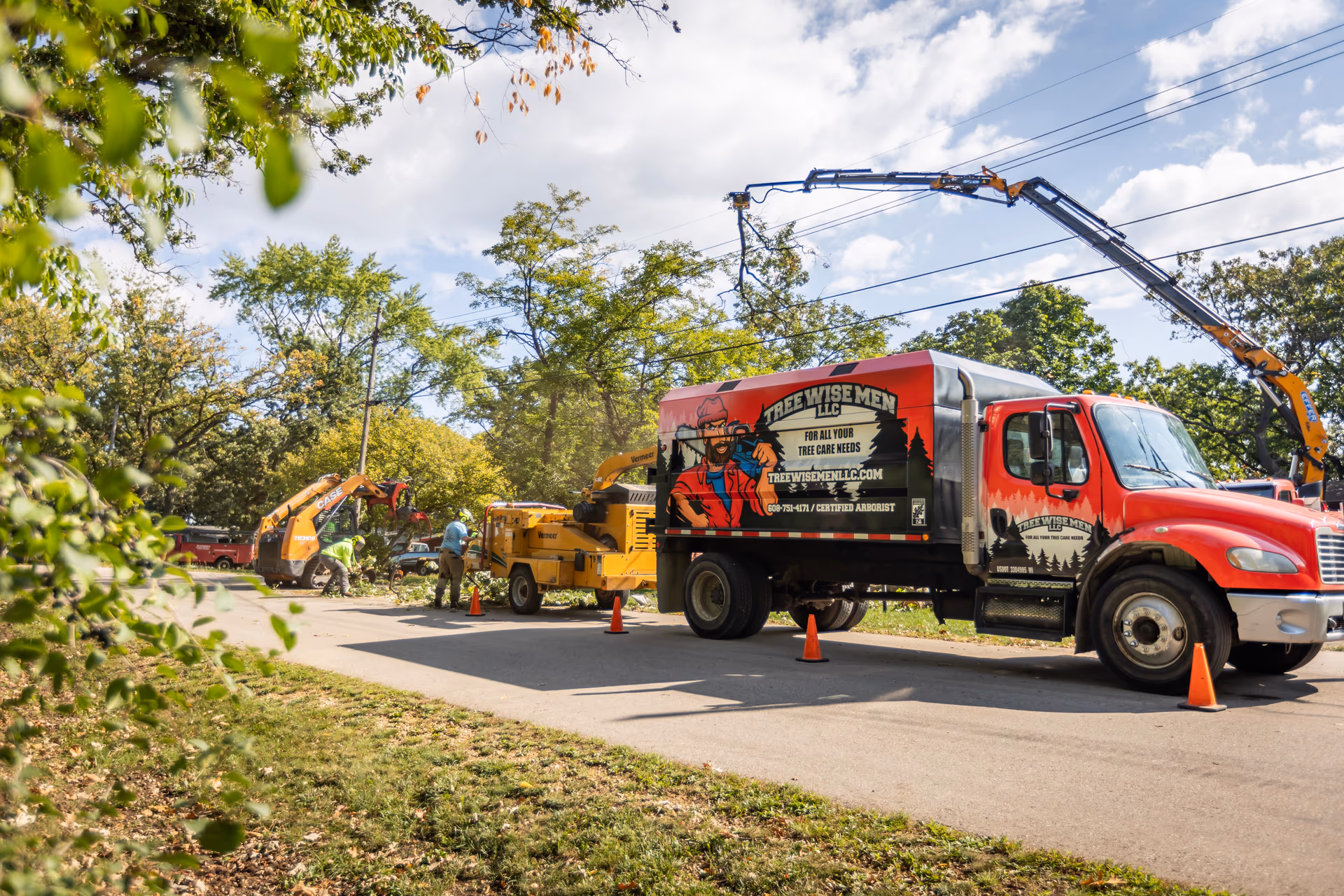 Tree Wise Men truck and chipper parked curbside at a residential job